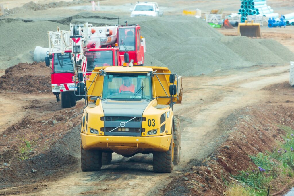 yellow and red heavy equipment on brown field during daytime